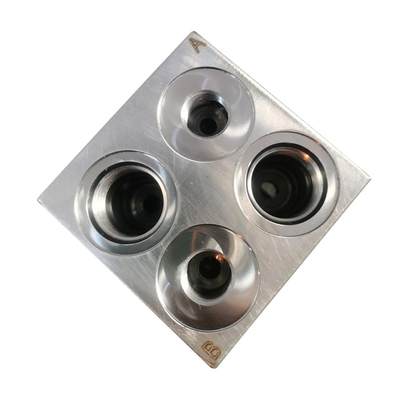 How do you adjust the pressure on a hydraulic valve block?